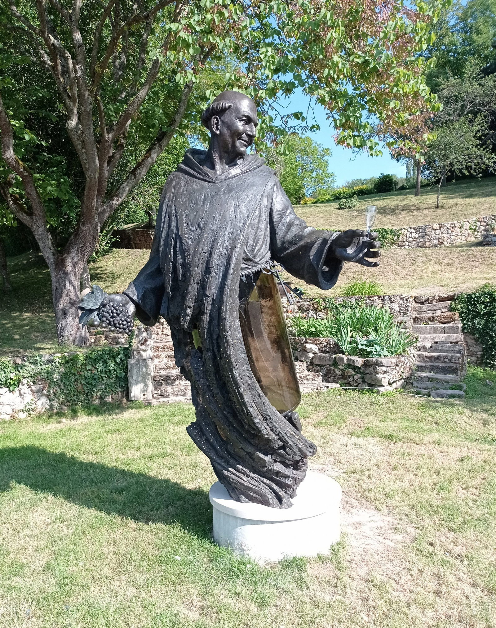 Statue of Dom Pérignon holding grapes and a champagne flute