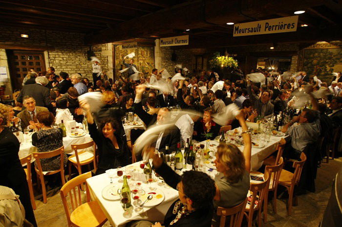 Guests enthusiastically wave napkins at a lively dinner event