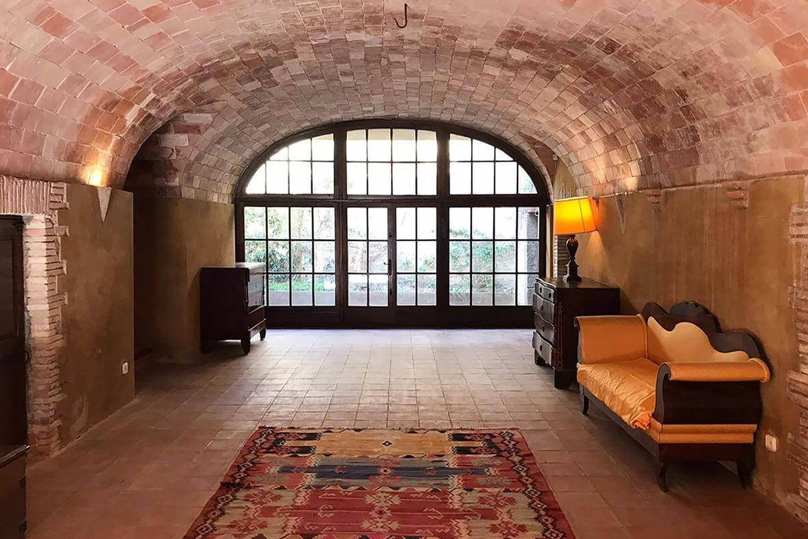 14. Empordà, Spain, features a beautifully vaulted ceiling of warm, exposed brick, complemented by a grand arched window.