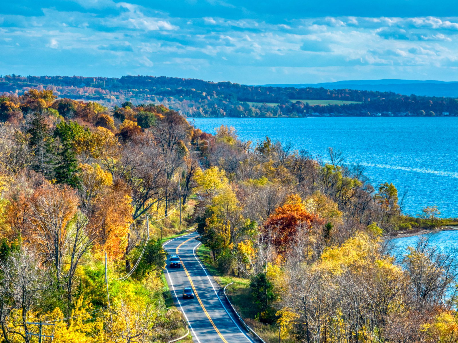 4. Finger Lakes, New York, USA, features a winding road with bright yellow double lines.