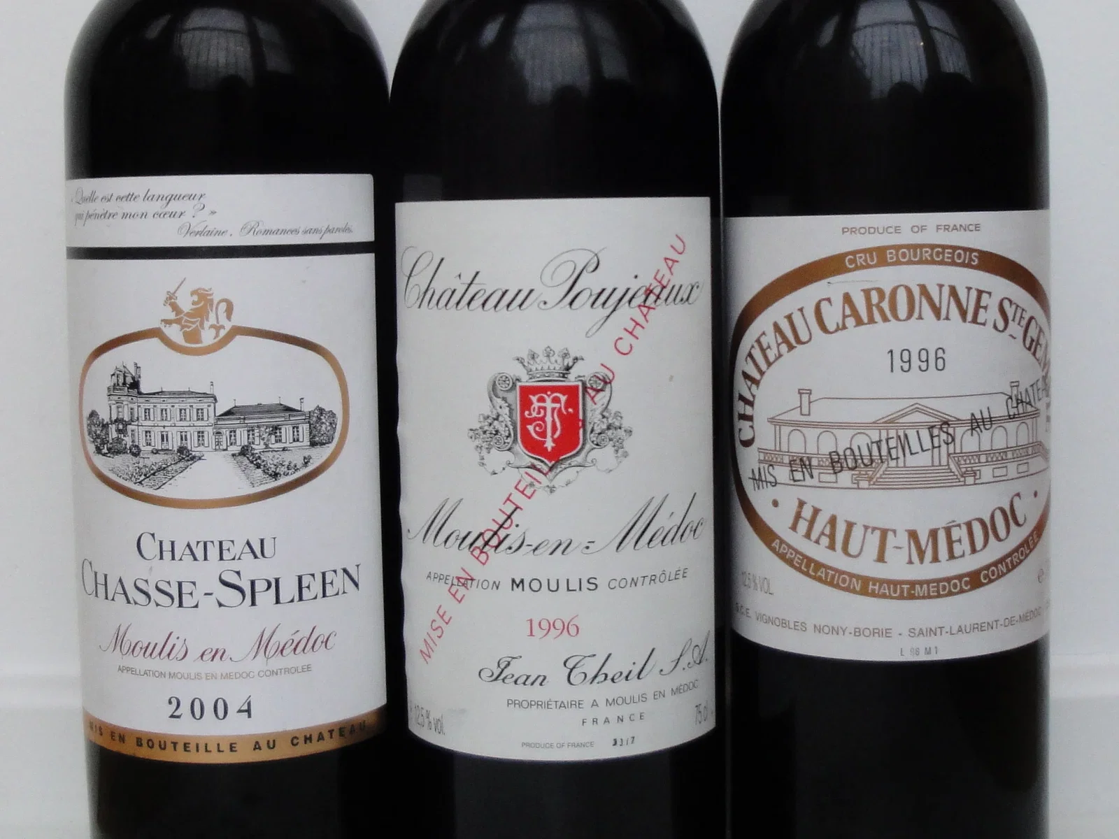 Three bottles of red wine, from left to right: Château Chasse-Spleen 2004, Château Poujeaux 1996, and Château Caronne Ste-Gemme 1996.