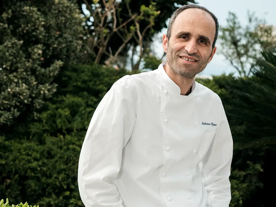 Salvatore Elefante, Executive Chef at Jumeirah Capri Palace, smiles against a lush garden backdrop.