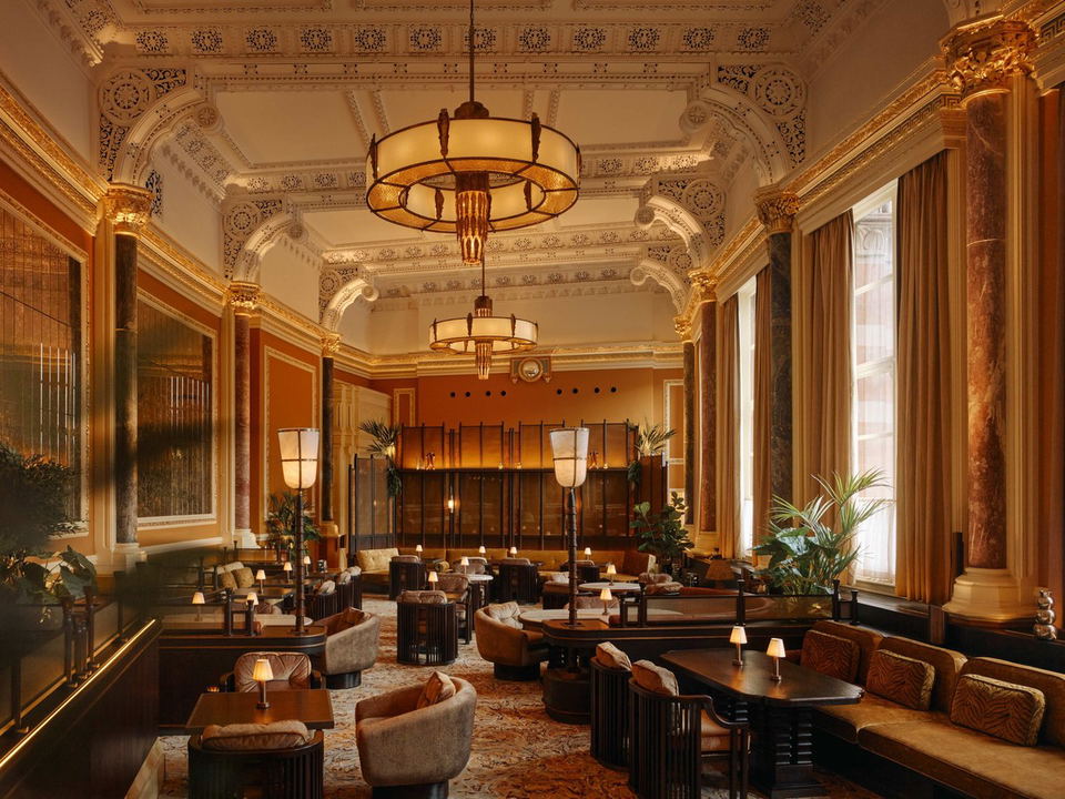 Luxurious restaurant interior with ornate ceilings, chandeliers, and comfortable seating