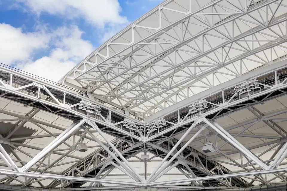 Arthur Ashe Stadium's retractable roof features a white steel truss and triangular lattice framework.