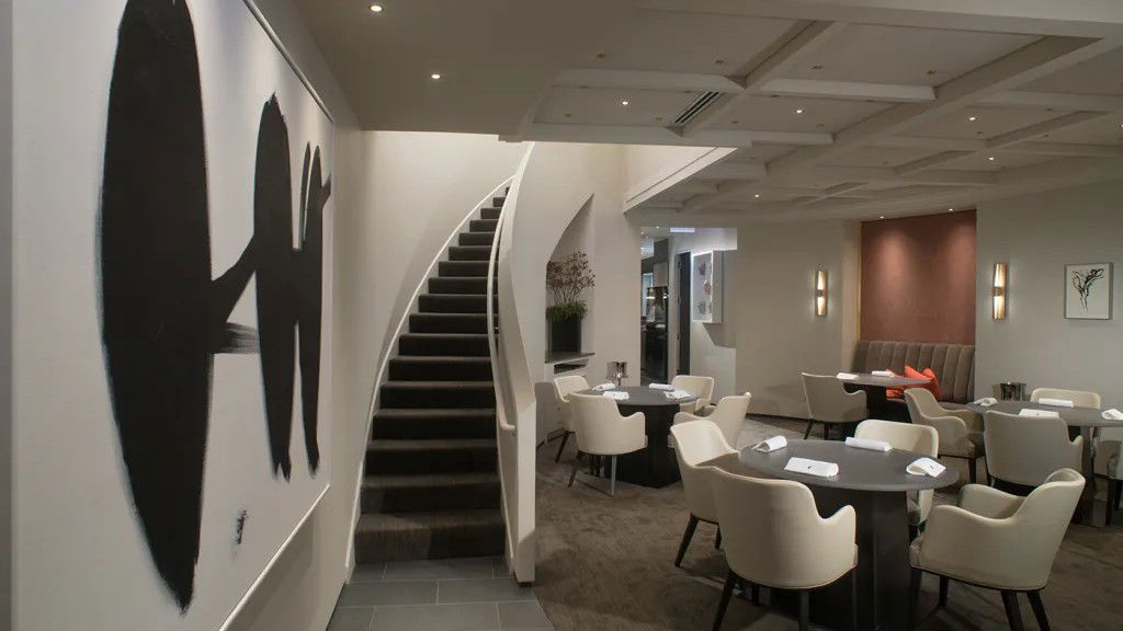 The Alinea Gallery dining room interior, spare and dramatically lit, with theatrical table settings.