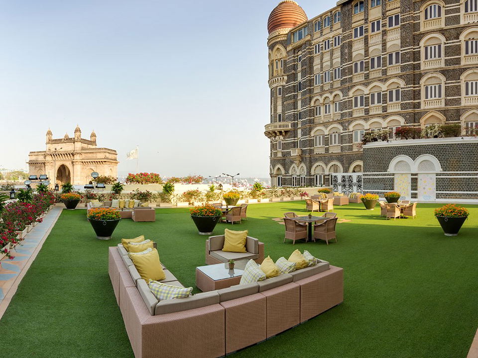 The Taj Mahal Palace hotel with its distinctive architecture and copper dome, with the Gateway of India visible in the background.
