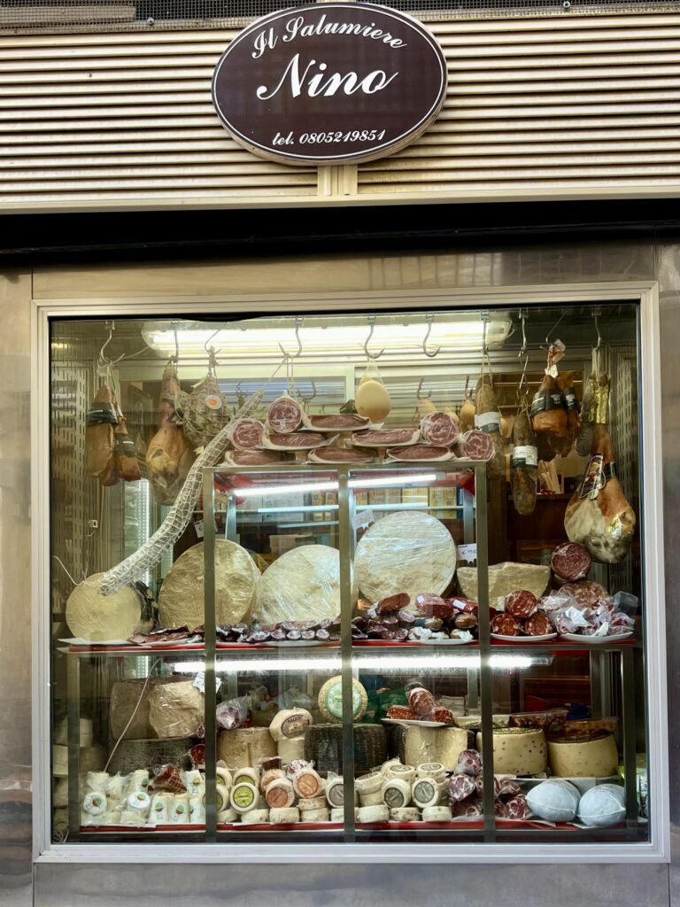 Antica Salumeria di Nicola Lapesara (Bari Vecchia) presents a vibrant display of red meats and white cheeses.