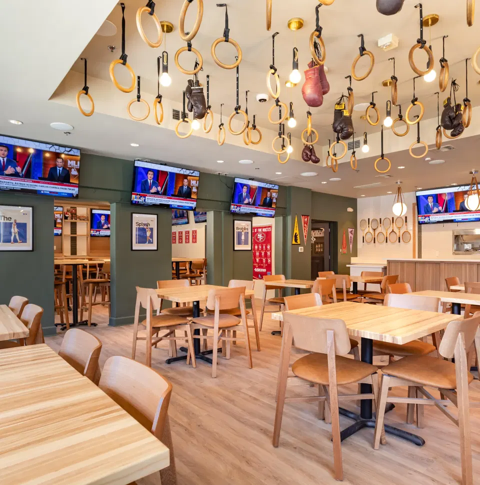 Piedays (Inner Richmond) features a ceiling adorned with numerous wooden gymnastics rings.