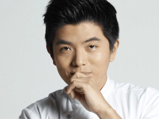 Thitid 'Ton' Tassanakajohn, chef of Saam, SoMa (San Francisco), poses in a white chef's coat.