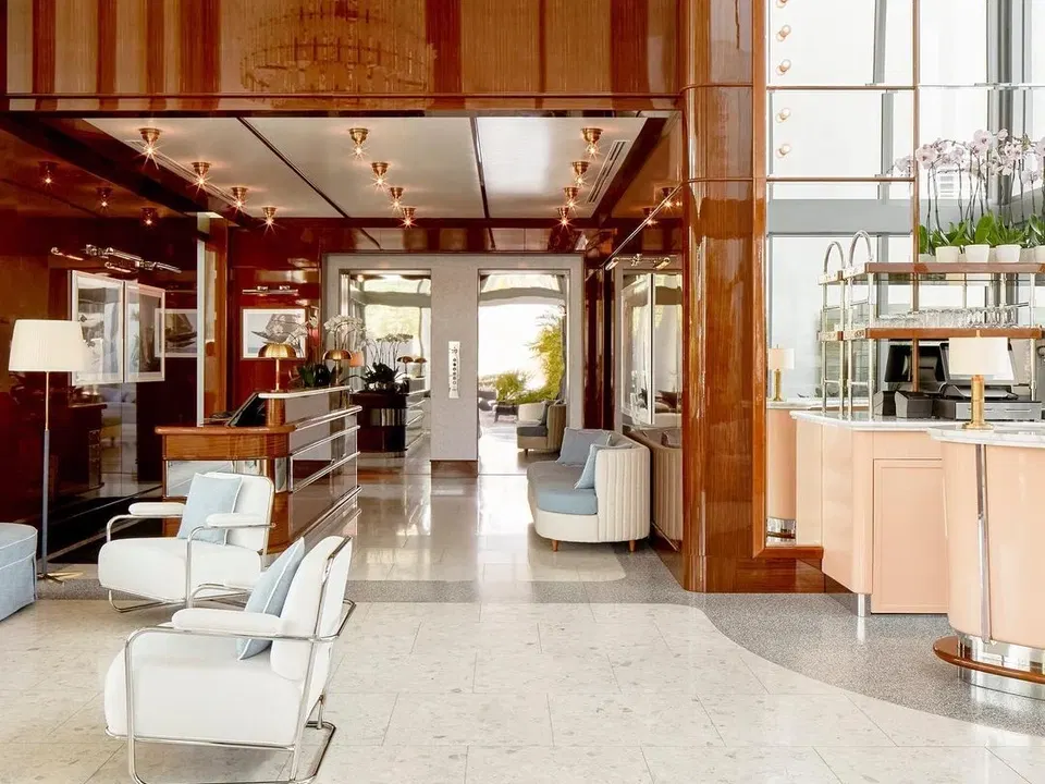 bellini restaurant coconut grove's elegant Art Deco lobby welcomes guests with high-gloss wood and a stunning Murano chandelier.