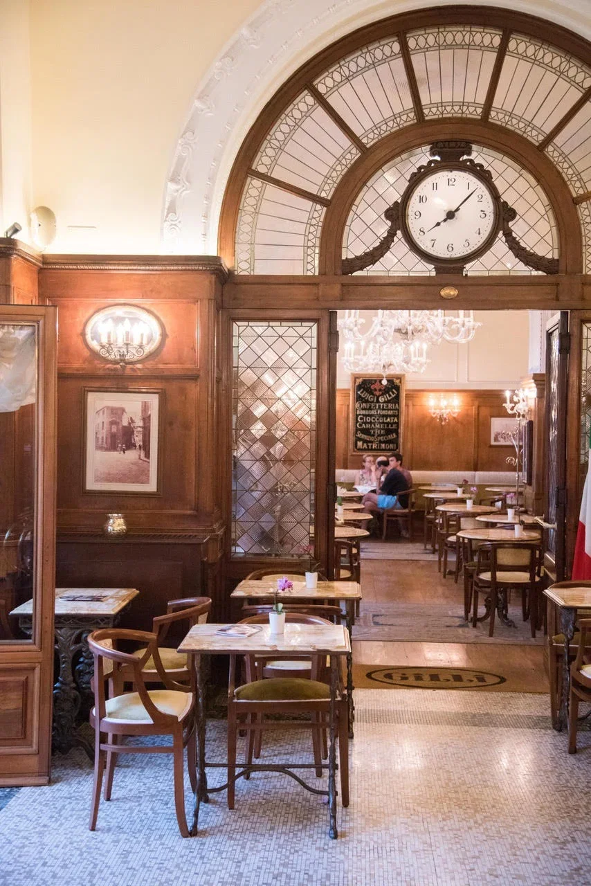 6. Caffè Gilli features a grand arched window with an ornate clock.