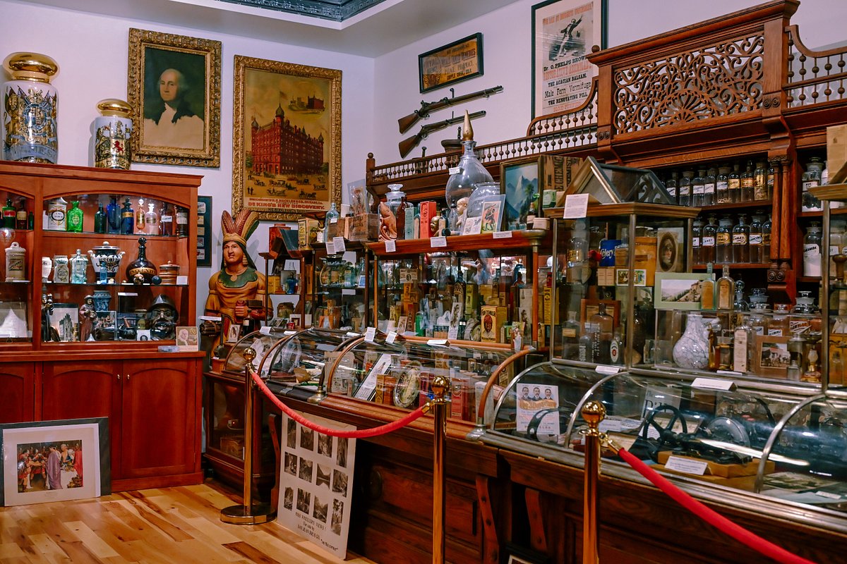 8. BAR Liquor Museum features ornate wooden display cases filled with countless antique bottles.