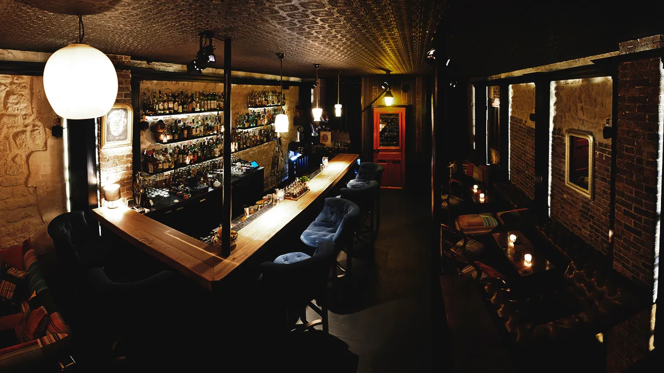 Paris Cocktail Bar Experience Summary, featuring a prominent glowing globe light above the bar.