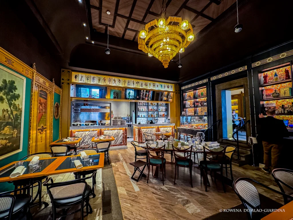 Salotto 42: Elegance in an Intimate Space features a striking, ornate yellow chandelier.