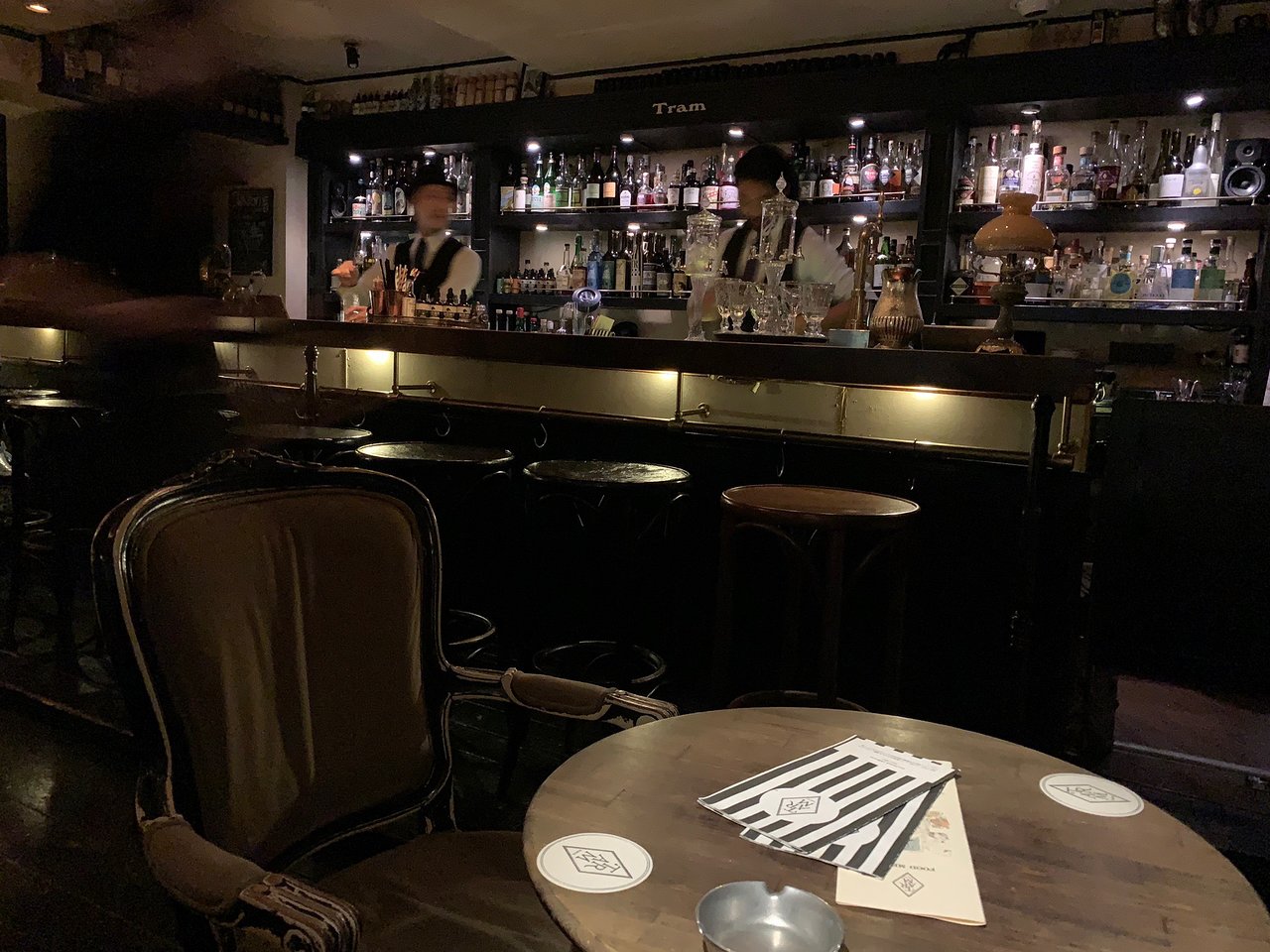 6. Bar TRAM (Ebisu) features a distinctive, amber-hued lamp illuminating the bottles behind the bar.