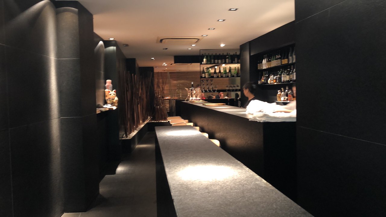 9. Koy Shunka features a sleek, dark interior with a long, illuminated counter.