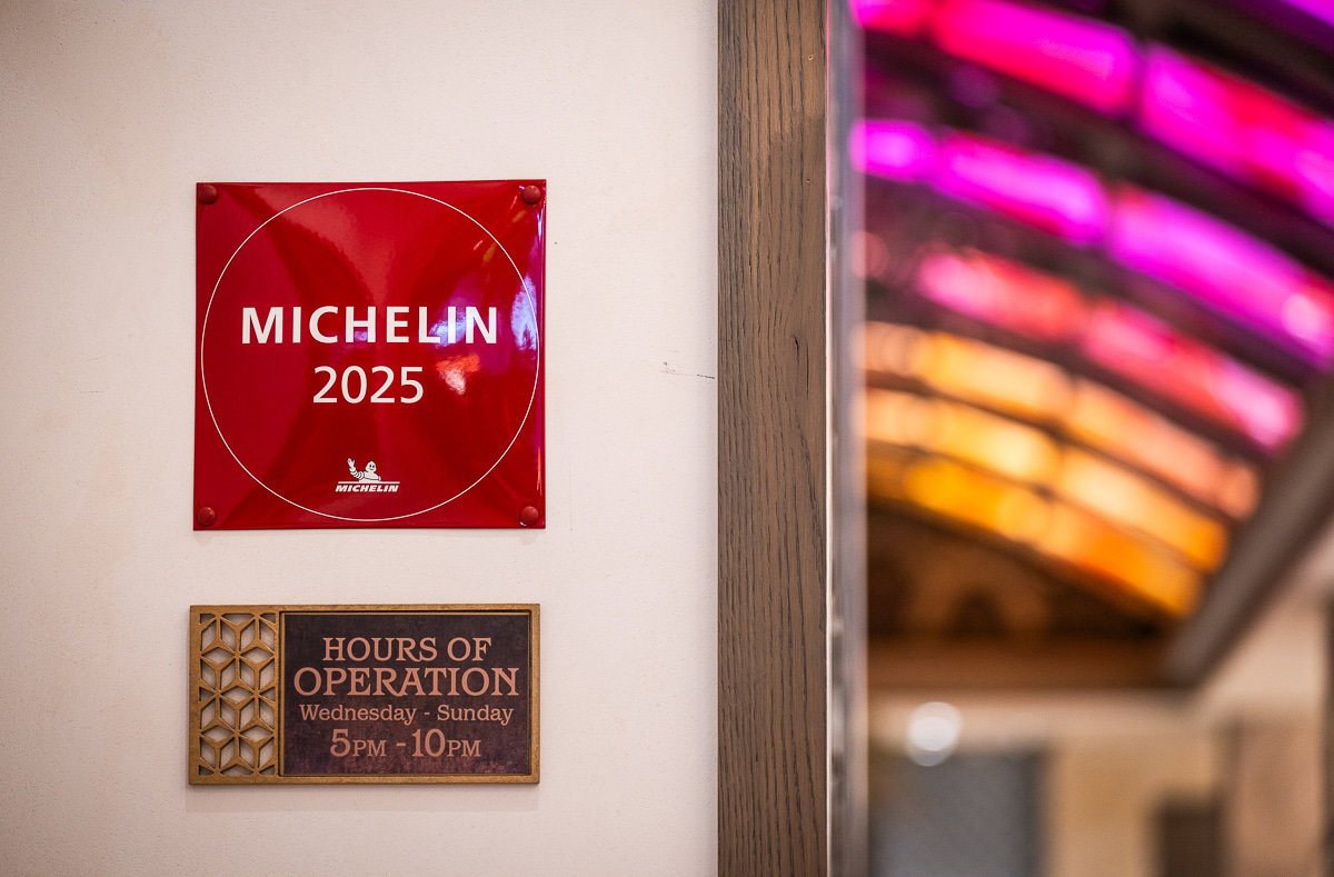 Michelin Recognition and Prestige, set against a backdrop of blurred, vibrant pink and orange lights.