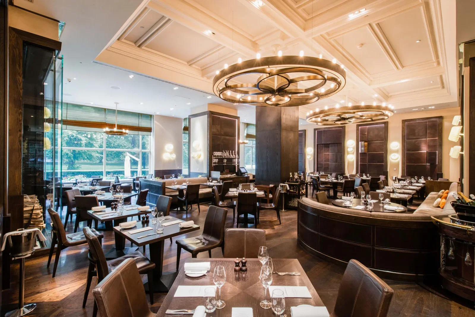 7. Dinner by Heston Blumenthal features prominent circular chandeliers illuminating the elegant space.