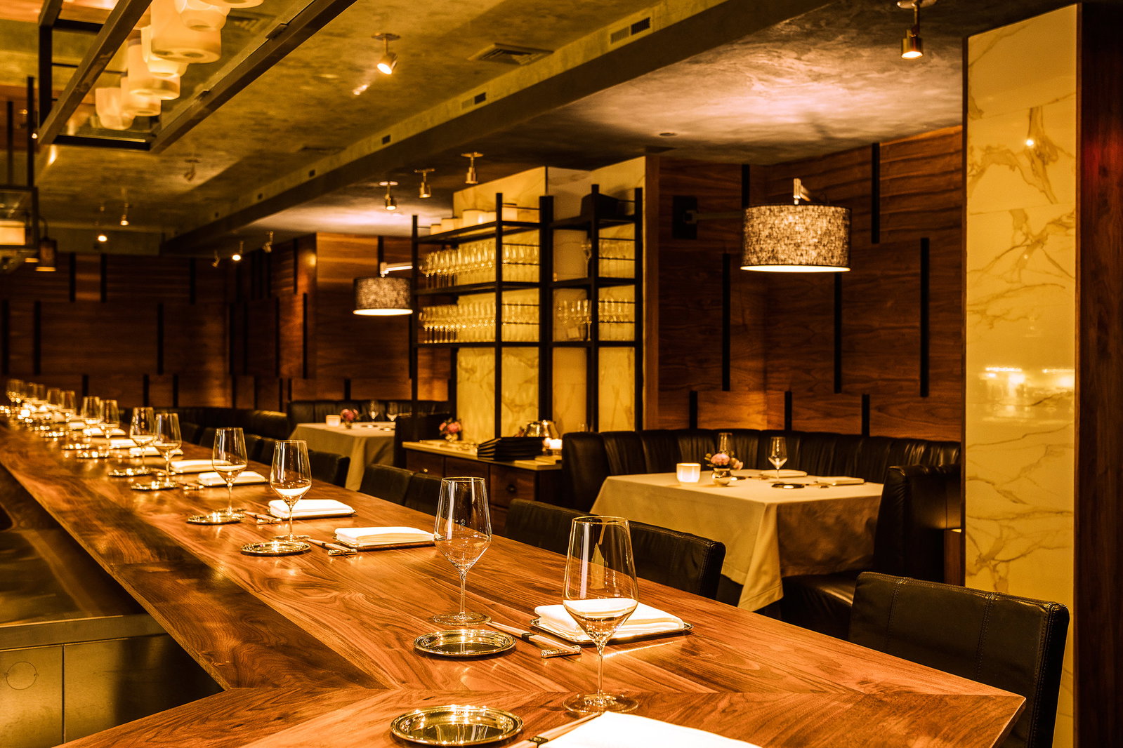 6. Chef's Table at Brooklyn Fare features a striking long wooden counter, meticulously set for guests.