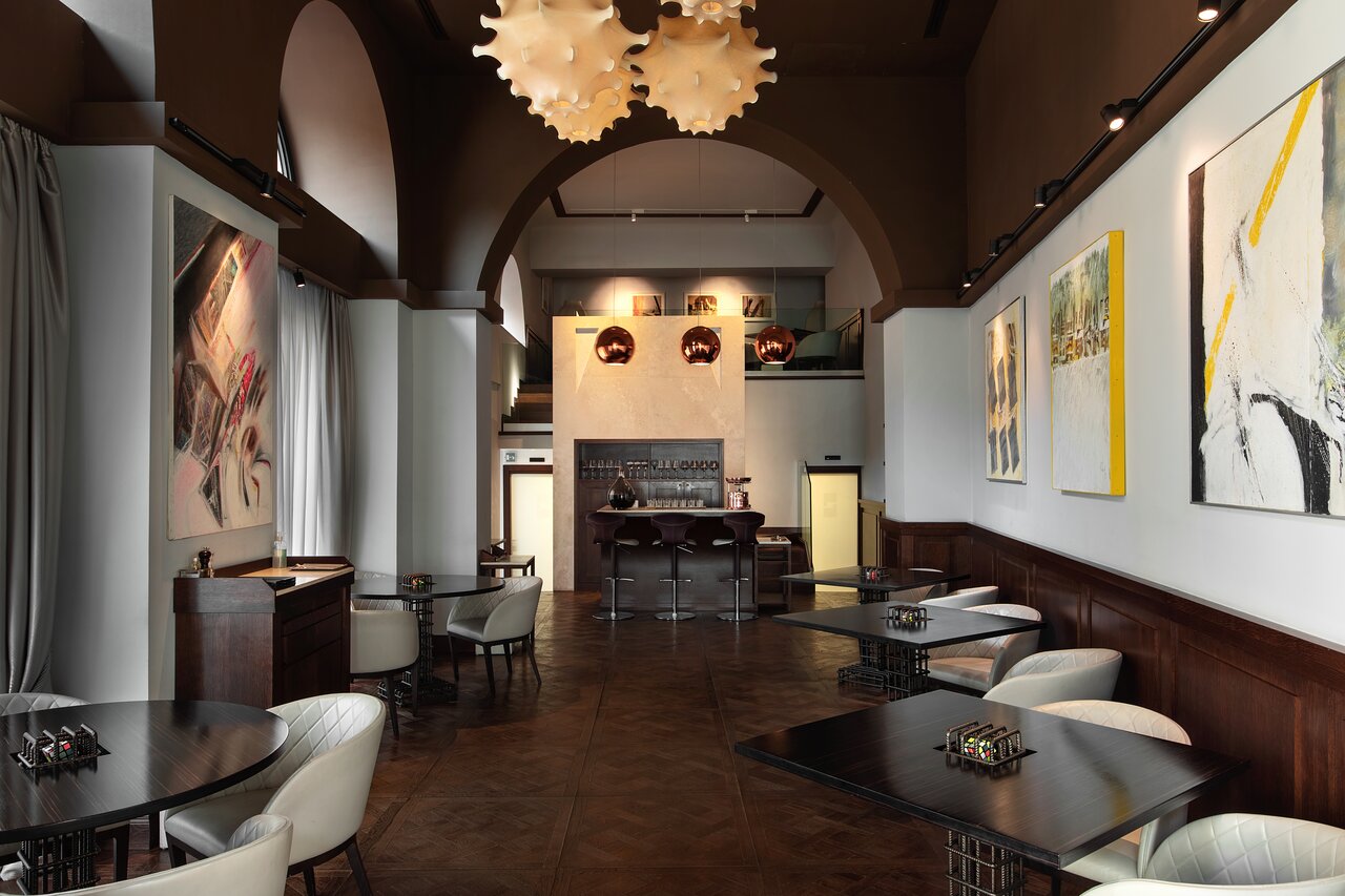 3. Pipero Roma features distinctive, organic-shaped chandeliers illuminating the elegant dining space.