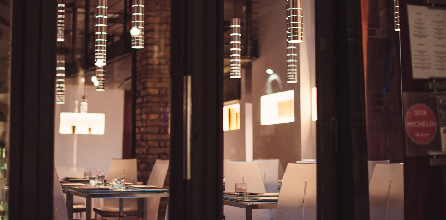 5. Glass Hostaria glows with warm, inviting light from its distinctive modern pendant fixtures.