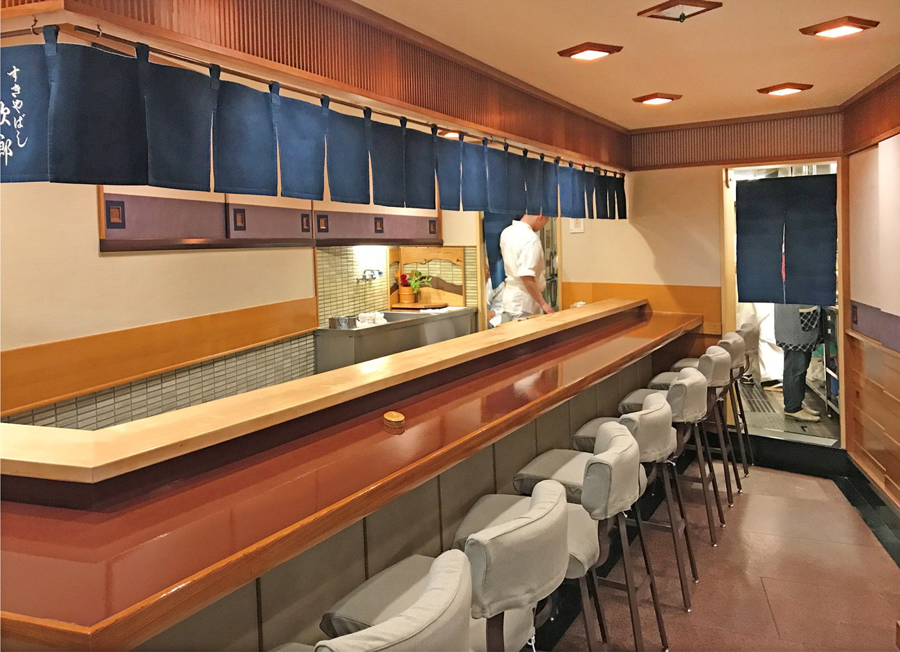 3. Sukiyabashi Jiro features a long, gleaming wooden sushi counter, inviting guests to an intimate experience.
