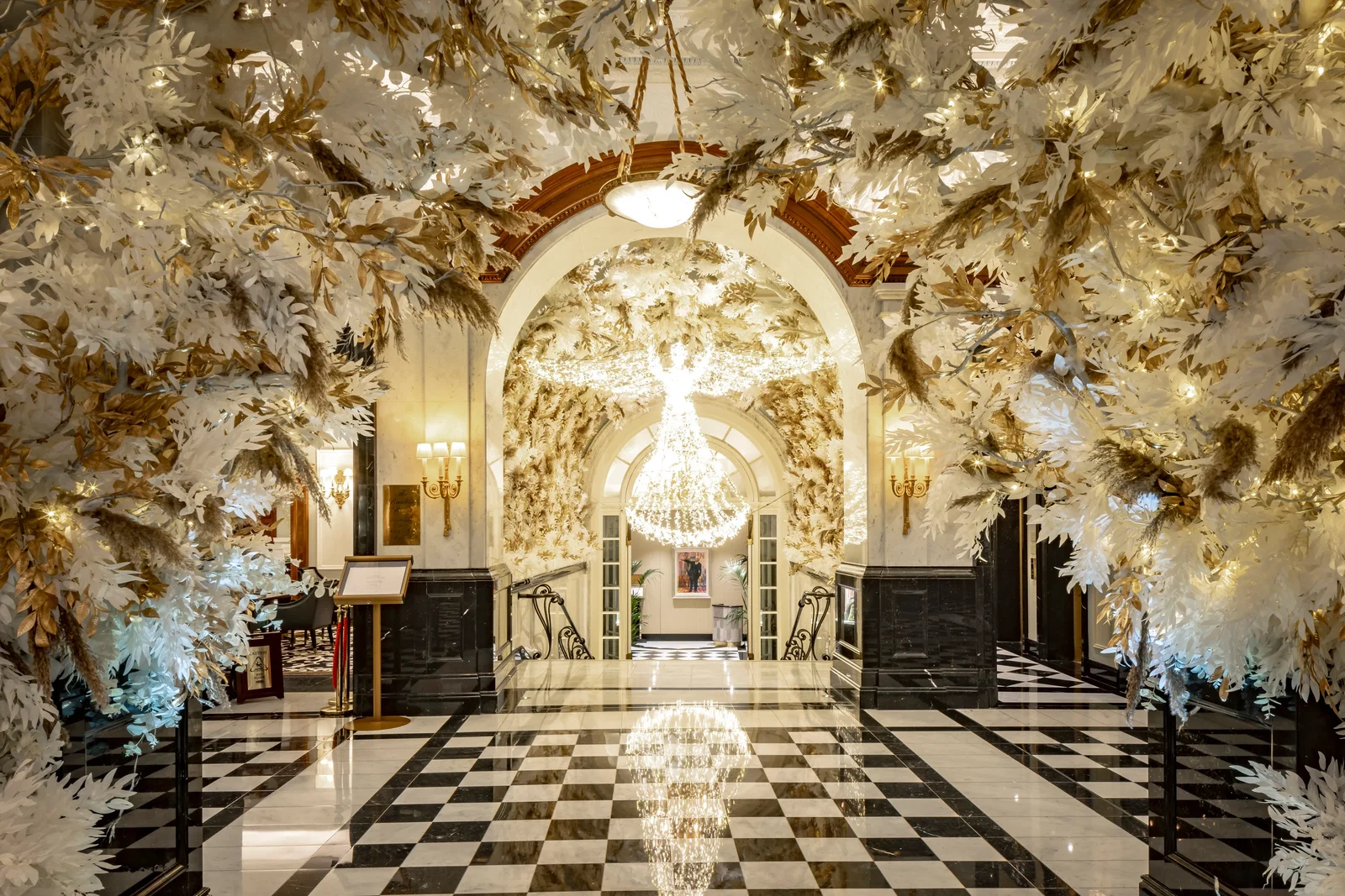 3. Hotel Savoy's grand chandelier casts a brilliant reflection on the polished checkered floor.