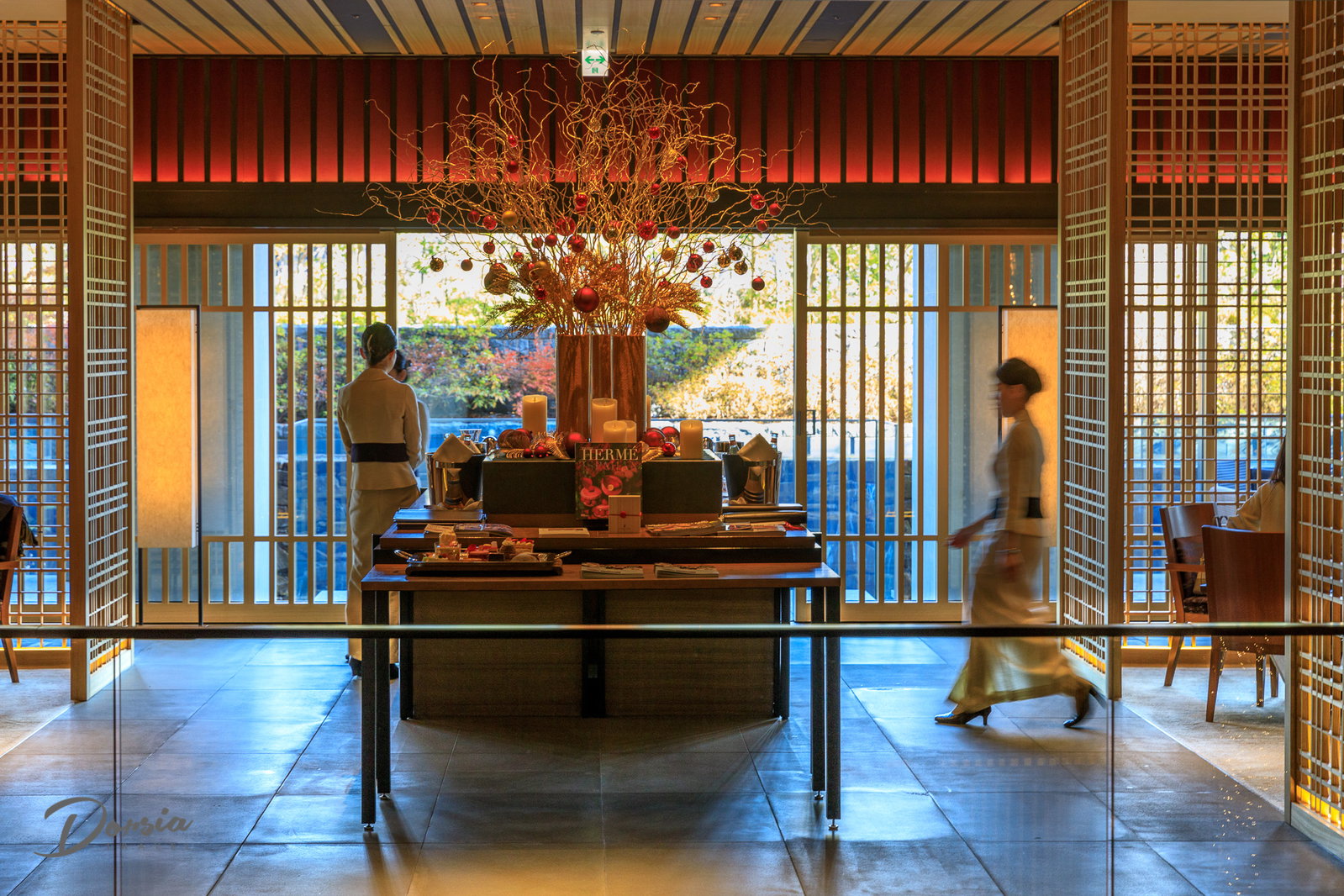 3. The Ritz-Carlton, Kyoto features a striking central floral arrangement adorned with festive red and gold ornaments.