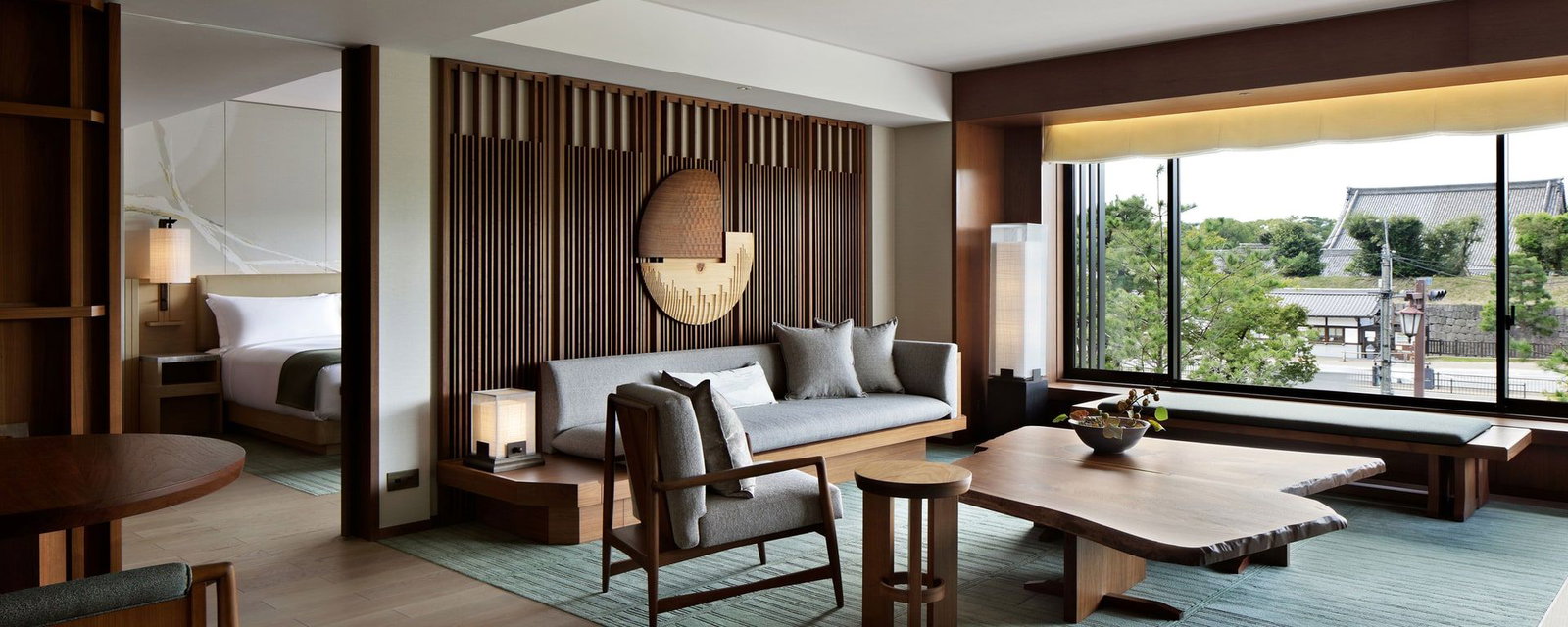 4. Hotel The Mitsui Kyoto offers a tranquil living space with expansive windows framing historic rooftops.