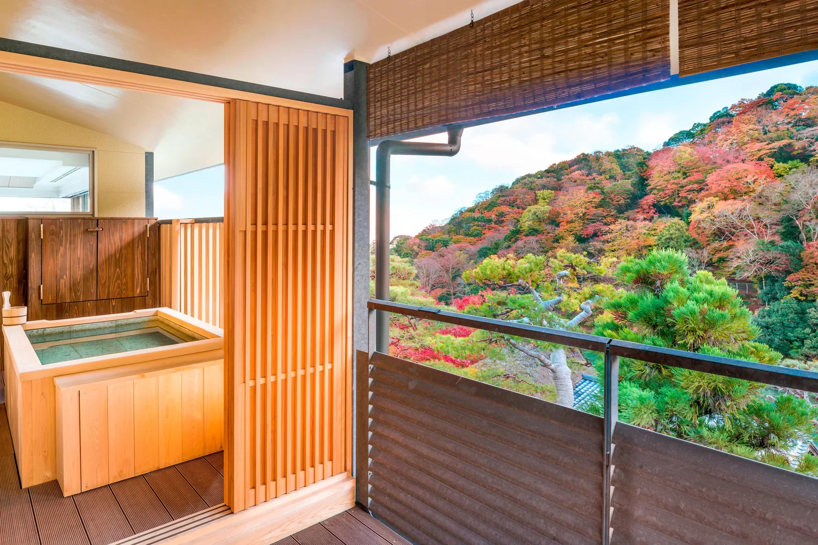 7. Suiran, a Luxury Collection Hotel, Kyoto features a wooden soaking tub overlooking a vibrant autumn hillside.