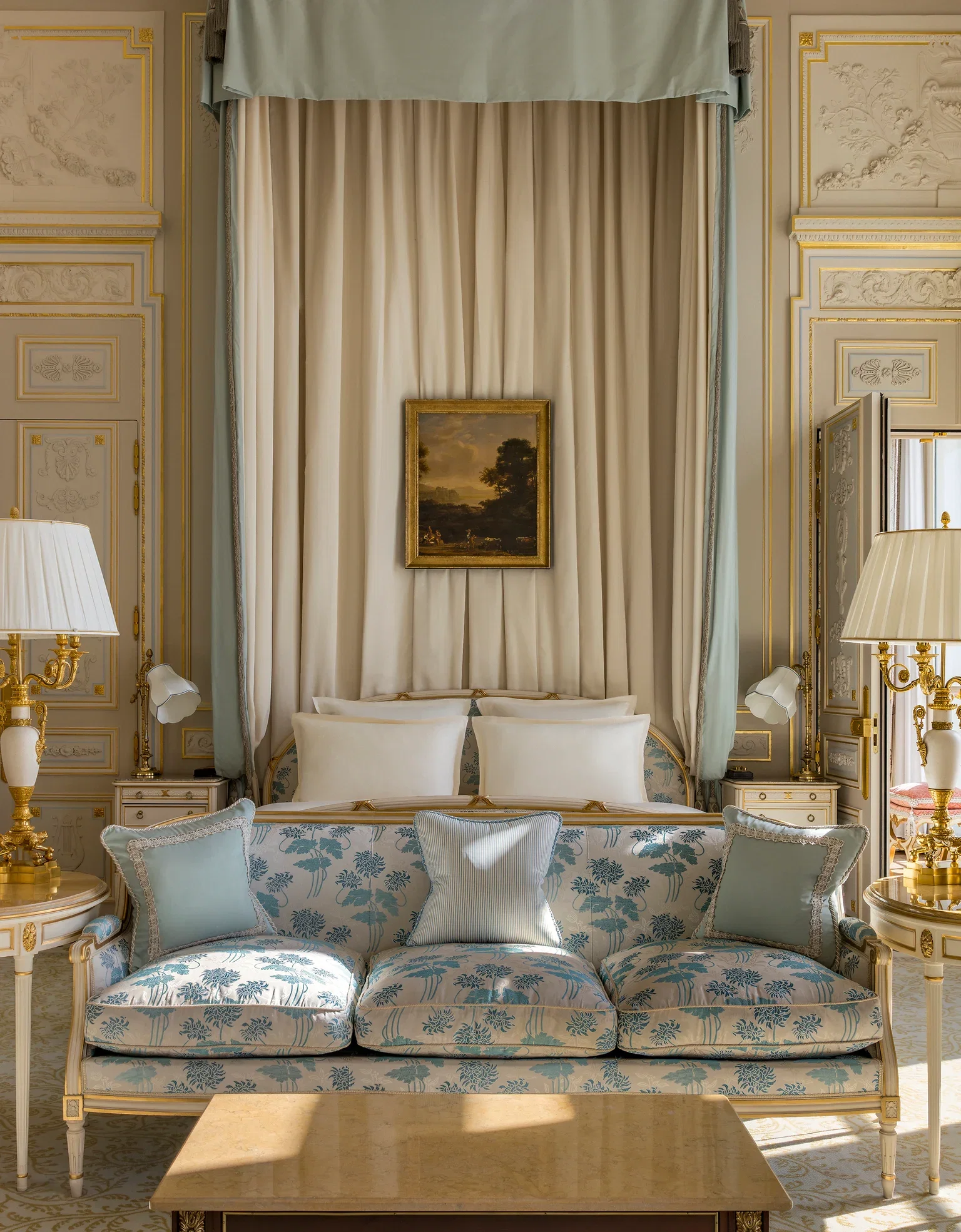 4. The Ritz Paris features a beautifully patterned sofa with soft blue floral motifs.