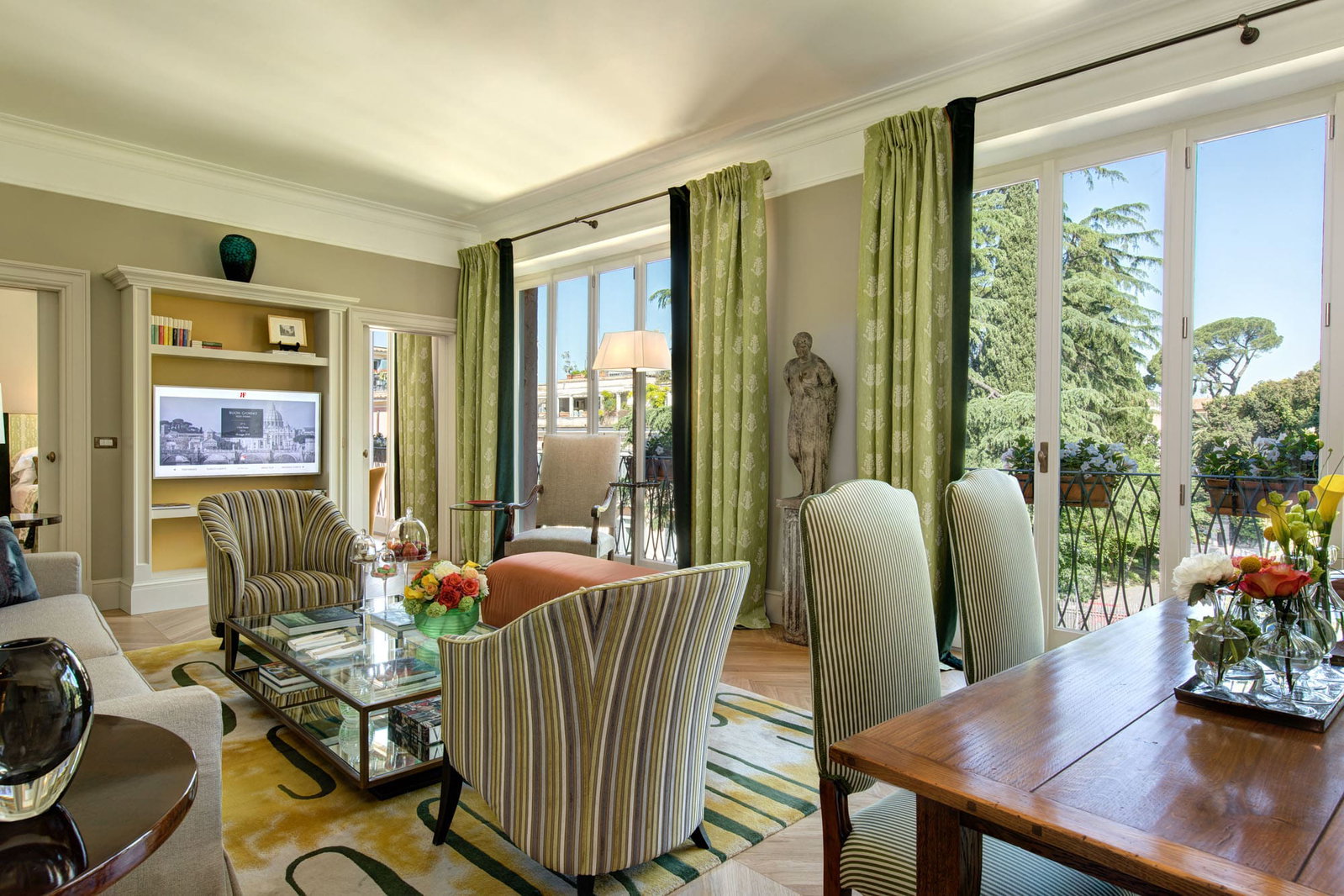 4. Hotel de Russie (Rocco Forte) offers large windows and a balcony overlooking a verdant garden.