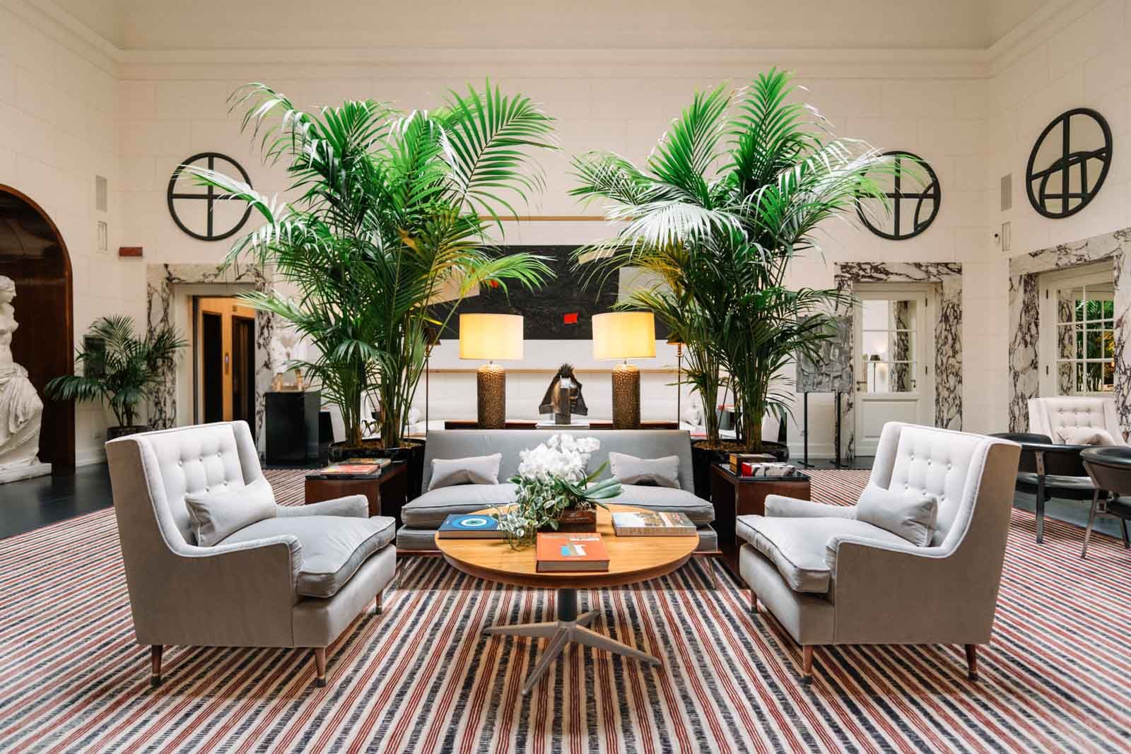 6. J.K. Place Roma features a striking lounge with a bold red and black striped rug.