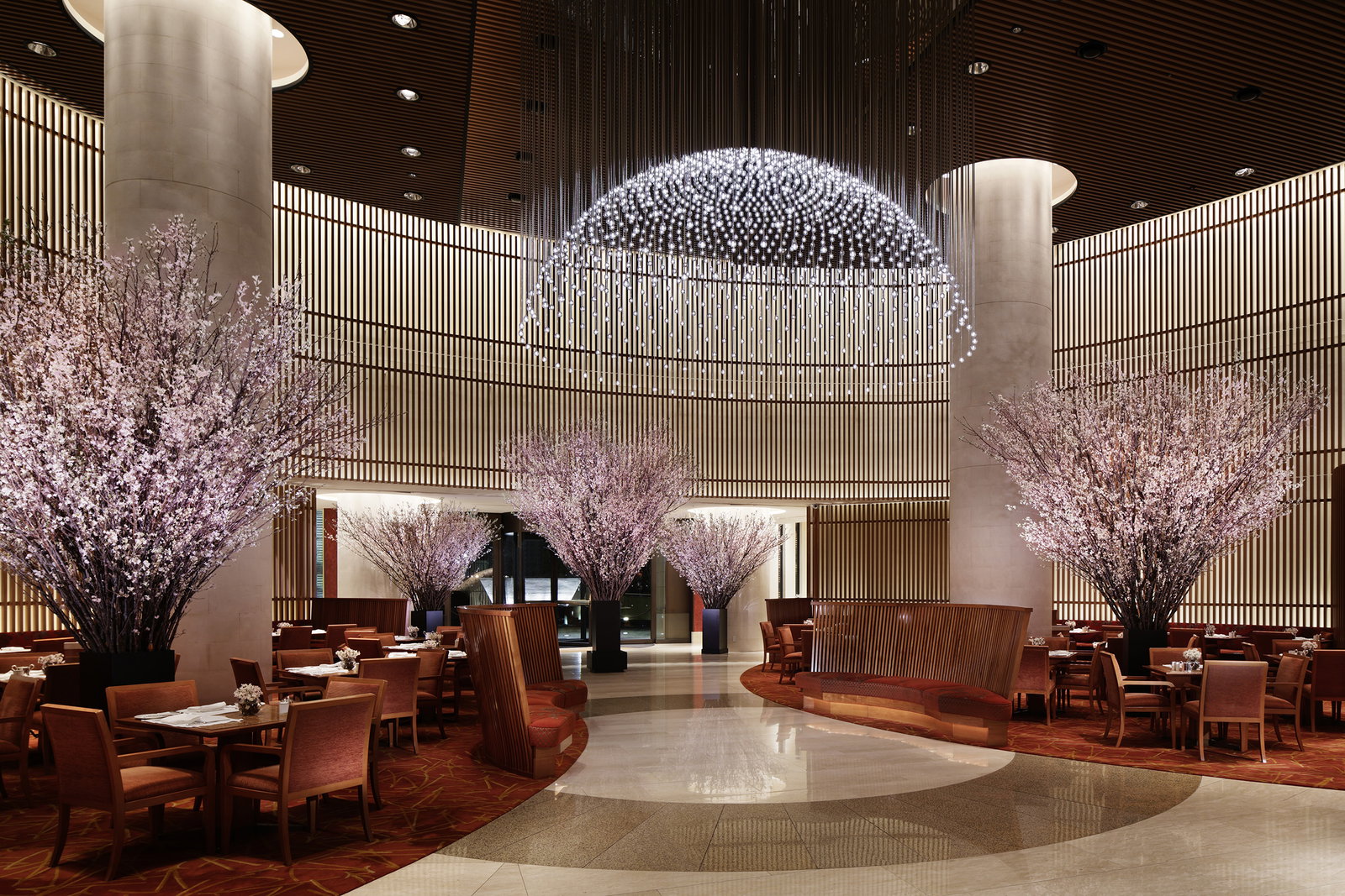 5. The Peninsula Tokyo's elegant lobby is beautifully adorned with vibrant pink cherry blossom trees.