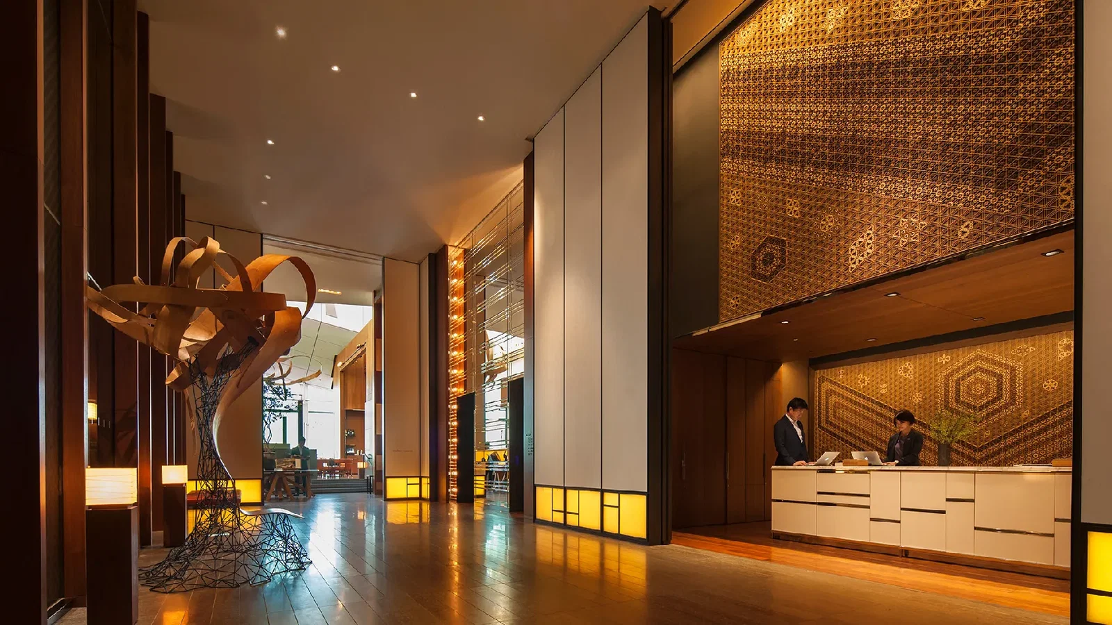 6. Andaz Tokyo (Toranomon Hills) showcases an intricate, golden patterned wall behind its welcoming reception area.