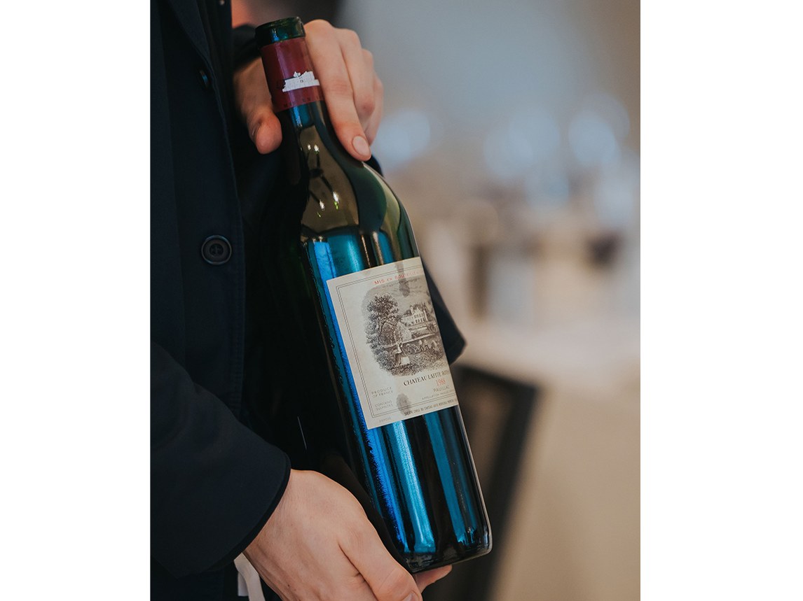 Château Lafite Rothschild 2019 bottle held by a professional, showcasing its iconic Pauillac label.