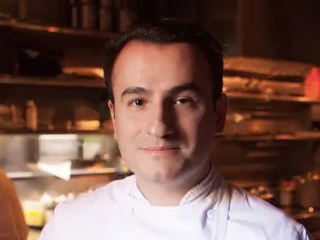 Chef Val Cantú, wearing a white chef's coat, in the kitchen of Californios.