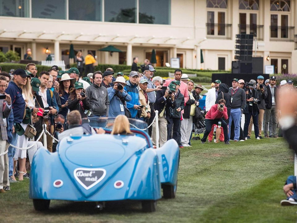 A vintage blue Darl'mat drives past eager spectators and photographers at Pebble Beach Concours d'Elegance.