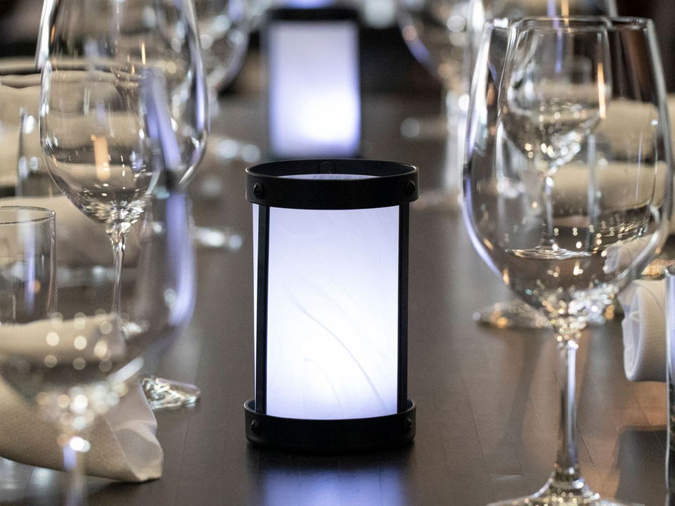 A formally set private dining table at Ferraro's Ristorante in Las Vegas, featuring wine glasses, water glasses, folded white napkins, and a glowing