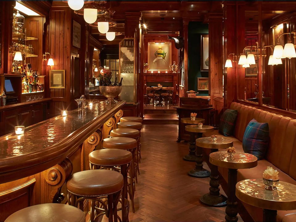 The Polo Bar: a warm, wood-paneled bar and dining room with leather seating and brass fixtures.
