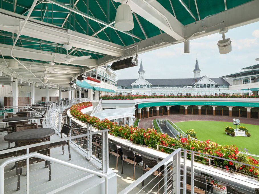 Millionaires Row Churchill Downs offers tiered seating, flower-lined railings, and iconic twin spires.