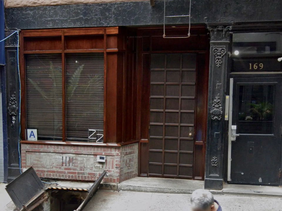 Exterior of ZZ's Clam Bar at 169 Thompson Street, featuring a dark wood facade, gridded door, and the street number 169.