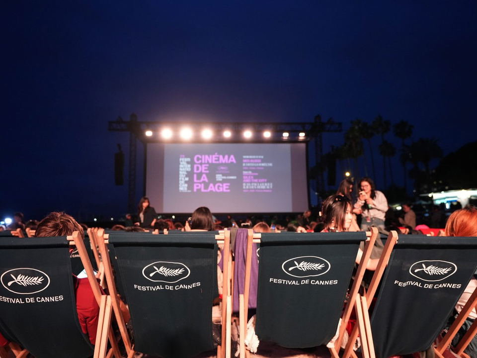 Cinéma de la Plage: An open-air night screening at Cannes Film Festival, featuring branded deckchairs.