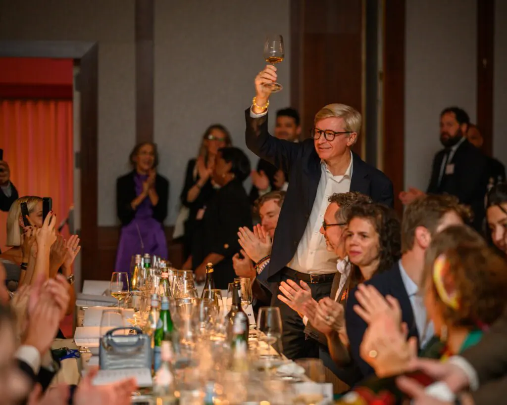 A guest raising a glass during the La Fête du Champagne gala dinner.