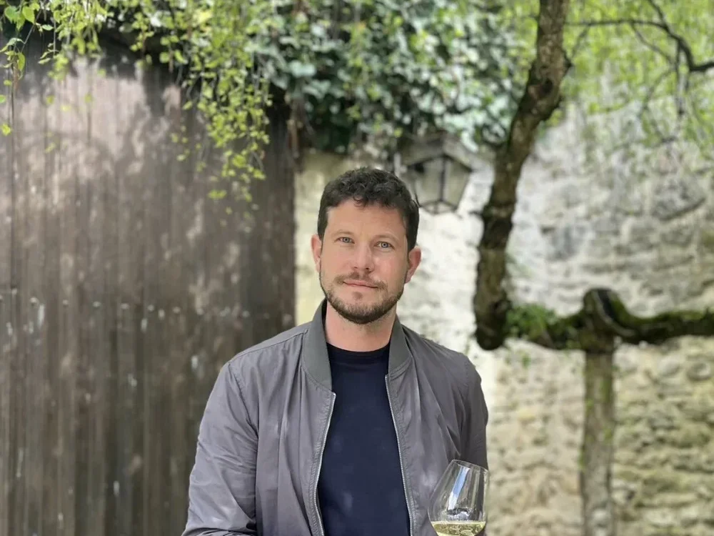 Alexandre Chartogne holding a wine glass outdoors.
