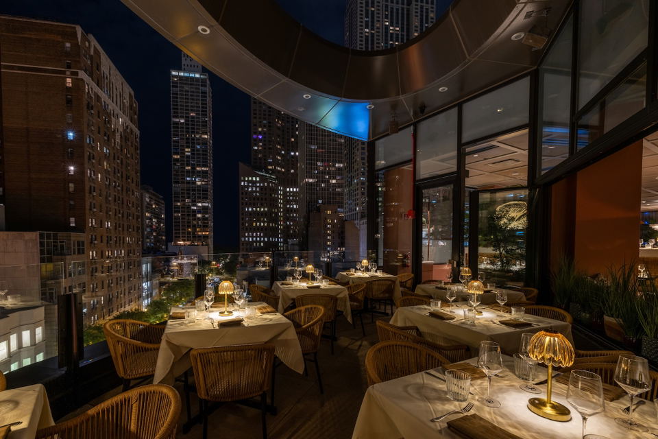 Arla (Gold Coast) features an inviting outdoor patio with warm, glowing table lamps.