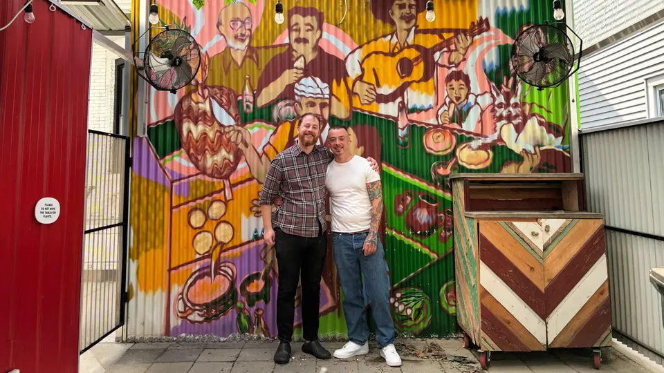 Chez Poulet (Logan Square) features a vibrant, multi-colored mural on its corrugated metal wall.