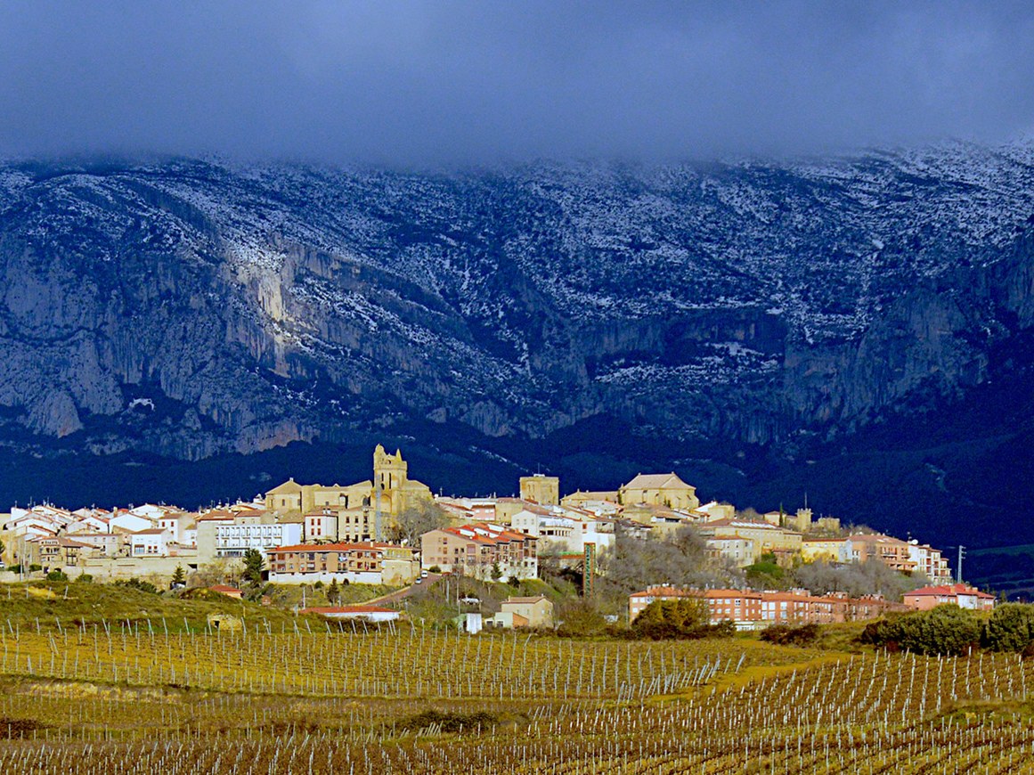 Laguardia, a medieval gem in Rioja Alavesa, stands amidst vineyards against snow-dusted mountains.