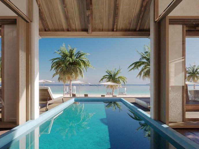 A luxury hotel pool area with wooden ceiling beams, floor-to-ceiling glass doors opening to a beachfront with palm trees.