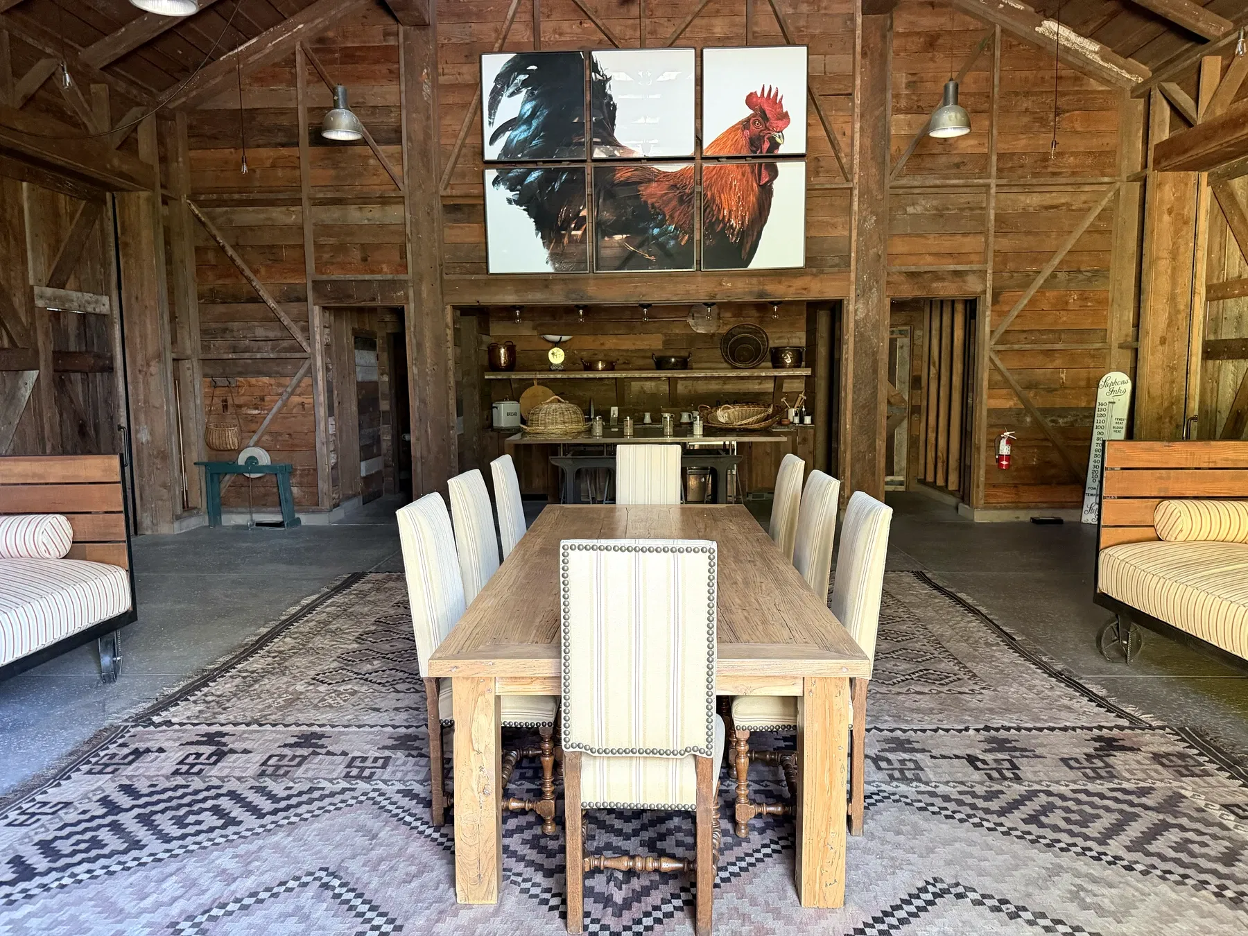 Reclaimed Dana Estates barn with long table, patterned rugs and large rooster artwork